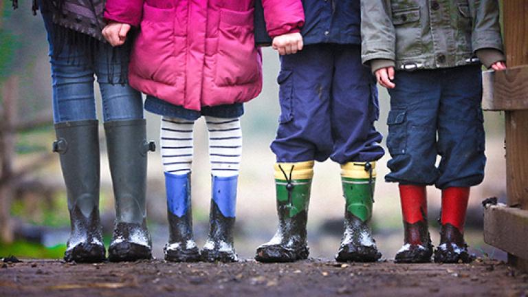 4 children in rain boots holding hands